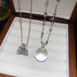 Close-up of pumpkin carriage and crystal ball pendants on a jewelry display box