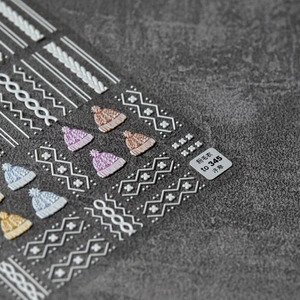 Detail of 3D embossed nail stickers featuring colorful knit sweater patterns and texture
