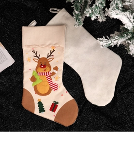 Detailed view of Christmas stockings with reindeer embroidery and white felt on pine needles