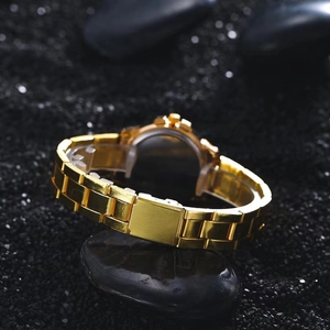 Detailed side view of a gold-tone quartz watch with metal chain strap on black stones
