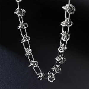 Detailed macro view of silver stainless steel chain with knot and oval link design