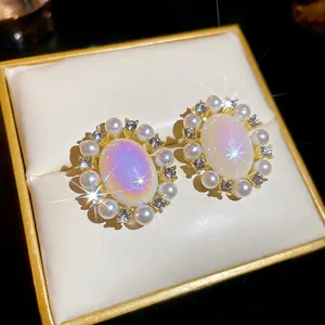 Vintage style oval gemstone earrings with pearls and diamonds in a luxury jewelry box