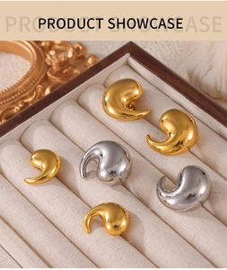 Macro view of gold and silver teardrop earrings displayed in a velvet jewelry box