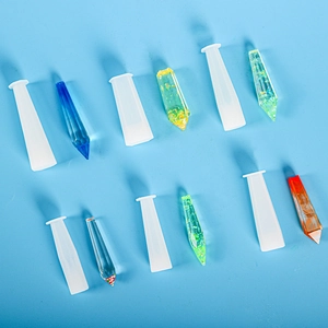 Detailed view of clear hexagonal crystal column resin molds and finished resin pendants