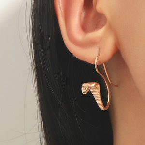 Vintage style gold cobra snake drop earring shown on a model for creative fashion look