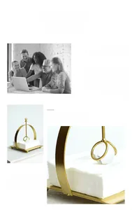 Detail of gold metal napkin holder with curved frame and crystal ball pressure bar