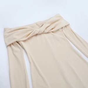 Dettaglio della tuta beige con scollo a barca e design a intreccio in tessuto a coste