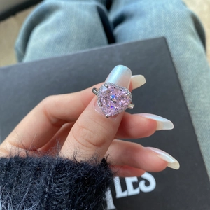 Détail montrant les facettes d'une pierre rose en forme de cœur sur une bague en argent.