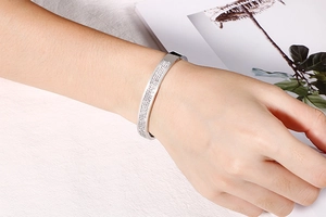 Bracelet argenté avec cristaux pavés rangés sur poignet dans un décor minimaliste