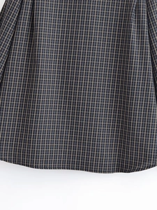 Détail de chemise à carreaux gris et jaunes avec coutures d'ourlet sur tissu doux