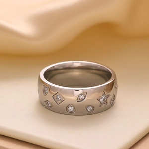 Macro shot of silver metal ring band featuring engraved stars and embedded zircons