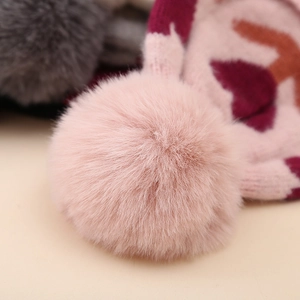 Detailed macro view of soft pink pom-pom and thick knit texture on warm winter baby hat