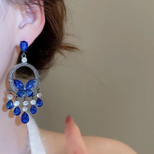 Detail of luxury butterfly drop earrings with blue crystal fringe and silver pins