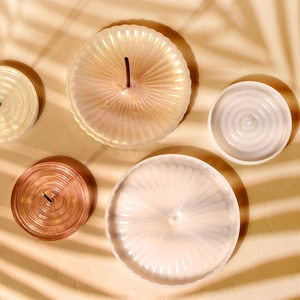 Macro detail of pearlescent incense tray with sunburst texture and central holder