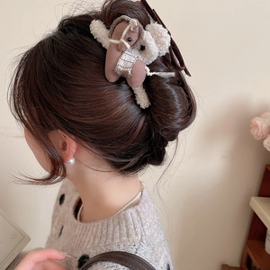 Detailed view of a brown plush pony hair claw clip worn on a model's hair style