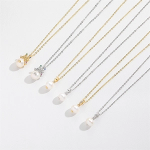 Macro view showing various pearl necklaces with crown pendants in gold and silver finishes