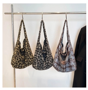 Three leopard print plush tote bags hanging on a rack showing different colors and soft textures