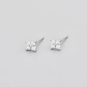 Detailed view of silver four-leaf flower earrings with sparkling cubic zirconia stones