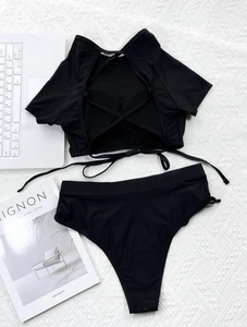 Detail of black two-piece bikini with lace-up back and high waisted side tie bottoms
