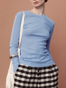 Detail of blue knit long-sleeve top showing fine bamboo texture and ribbed fabric finish