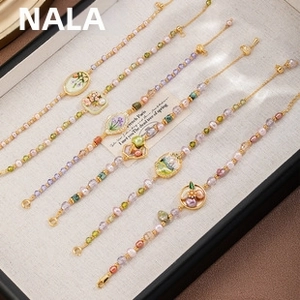 Detailed close-up of 5-piece floral pearl bracelet set with enamel flower charms