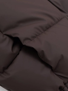 Detail of dark brown quilted puffer vest showing fabric texture and padded stitching
