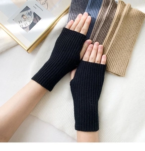 Detail showing the vertical ribbed knit texture and soft yarn of black fingerless gloves