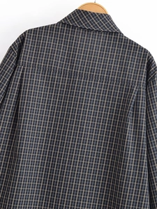 Détail d'une chemise à carreaux gris et jaune montrant la couture du dos et la texture