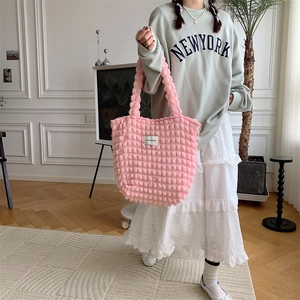 Detailed close-up of pink bubble textured tote bag with a minimalist white fabric label
