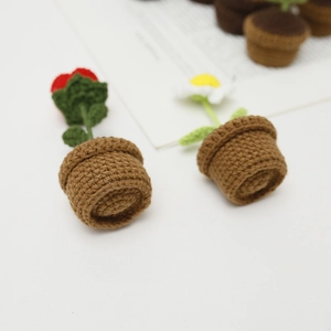 Handmade crochet potted plants with red flowers and white daisies in brown woven pots
