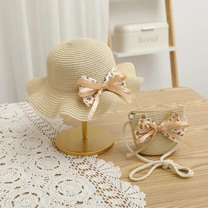 Détail d'un ensemble chapeau de paille enfant et mini sac assorti avec nœuds floraux