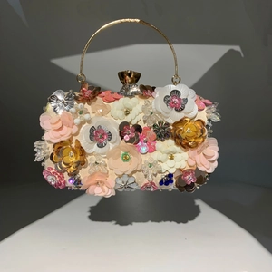 Detailed close-up of 3D floral beading and golden ring handle on champagne evening clutch