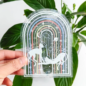 Close-up of static cling suncatcher with rainbow arch and cats design on transparent vinyl