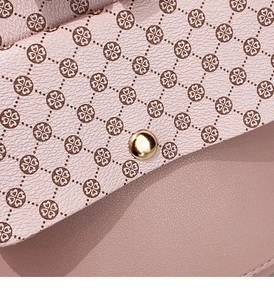 Detail of the pink faux leather texture and gold metal buckle on the crossbody bag