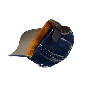 Detail view of denim baseball cap with yellow sweatband and brown leather strap