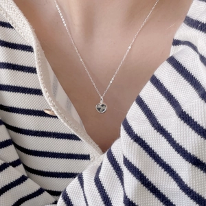 Macro shot of 925 sterling silver heart pendant with zebra stone on a silver necklace