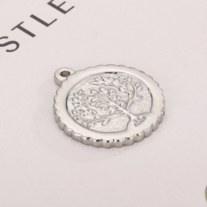 Silver stainless steel Tree of Life pendant with gear edge on beige fabric background