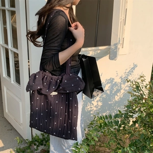 Close-up of black floral canvas tote bag featuring ruffled edges and vintage texture