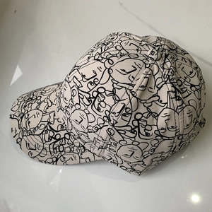 Unisex beige cotton baseball cap featuring abstract black face print and curved brim