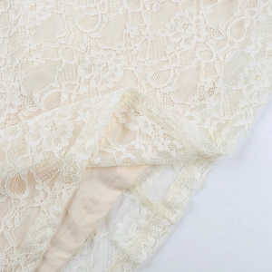 Close-up of beige lace dress detailing with intricate floral patterns and smooth lining