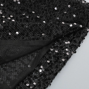 Macro detail of black sequins and delicate mesh fabric for backless evening dresses