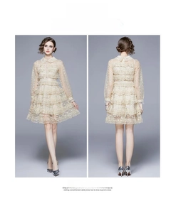 Détail de la robe en dentelle abricot clair avec col Claudine et jupe à plusieurs niveaux