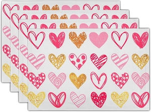 Close-up of four linen placemats with romantic heart patterns for Valentine's table decor