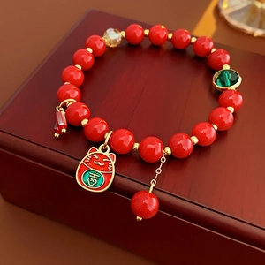 Détail du bracelet en perles rouges avec charm chat Maneki-neko doré et caractère Ji