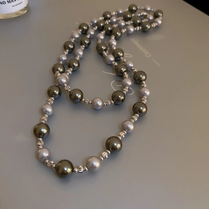 Vue détaillée du collier en perles rondes grises et argentées aux reflets brillants