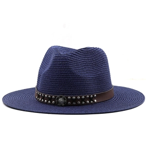 Classic navy straw cowboy hat with brown leather rivet band and vintage metal emblem