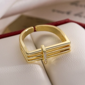 Minimalist 18K gold-plated geometric open ring with cubic zirconia on white leather