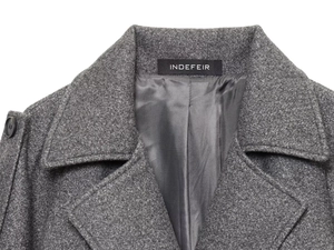 Detail shot of a grey wool coat collar and high-quality textured fabric with brand label