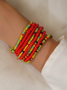Close-up of colorful handmade beaded waist chains in bohemian style on model wrist