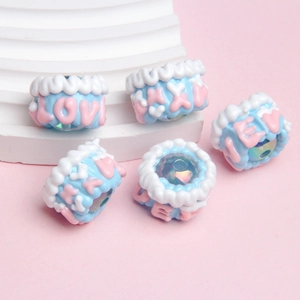 Macro shot of blue and white resin crown-shaped DIY beads with LOVE engraving
